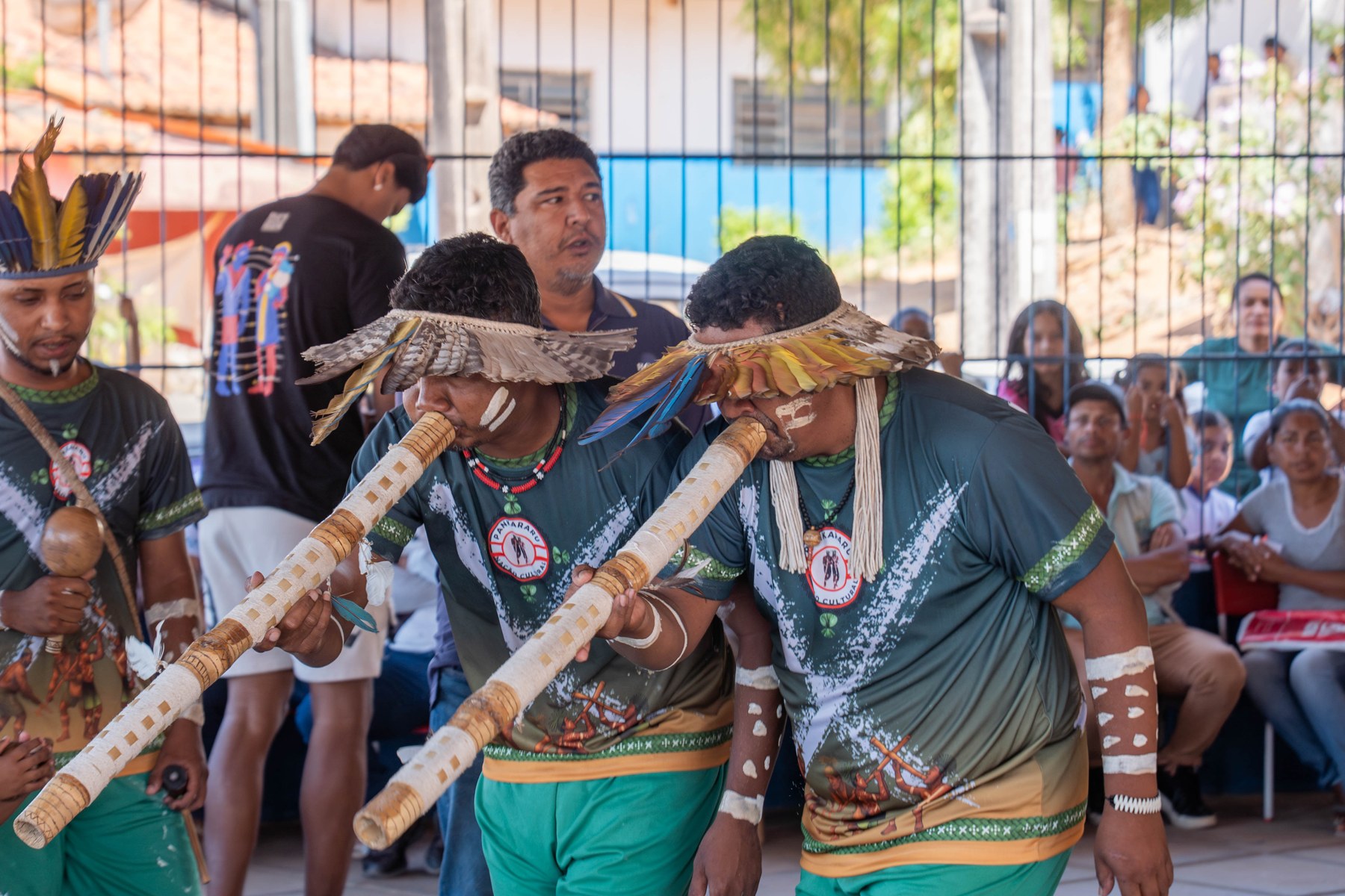 Indígenas Pankararu dançando com maracá e flautas, com cocares de penas